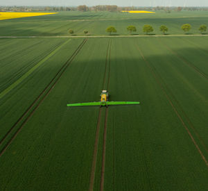 Tractor with field sprayer when applying pesticide against pesticide