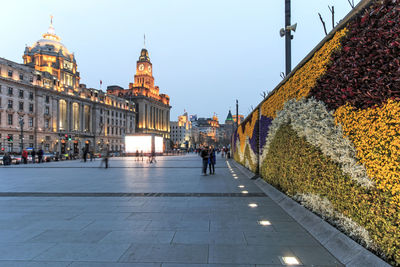 People on bund by shanghai customs house at dusk