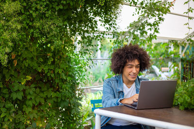 Young woman using laptop while sitting at park