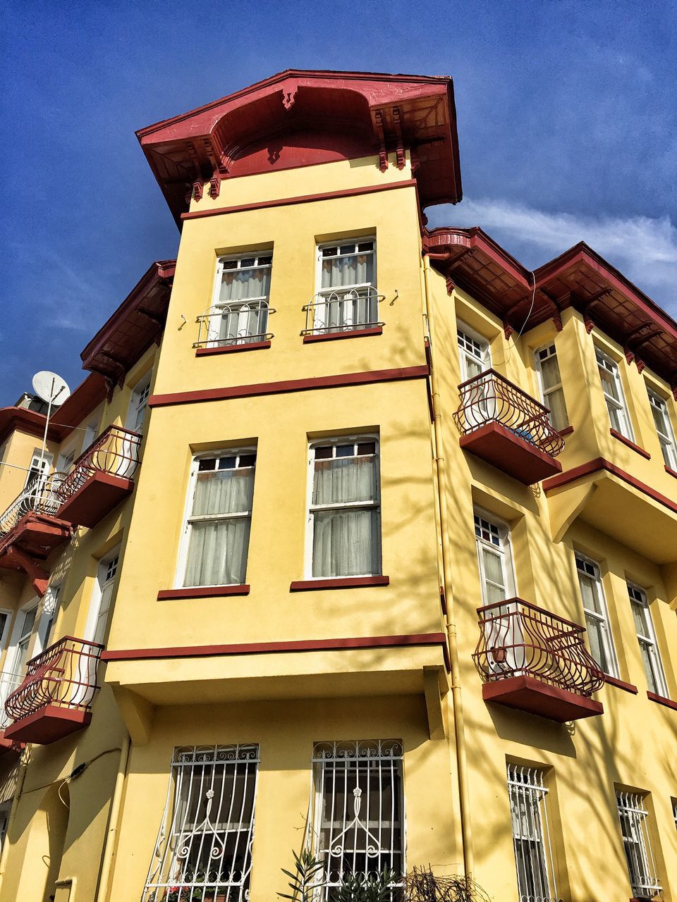 building exterior, architecture, window, low angle view, built structure, balcony, sky, yellow, outdoors, no people, day, city