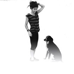 Portrait of young woman with dog against white background