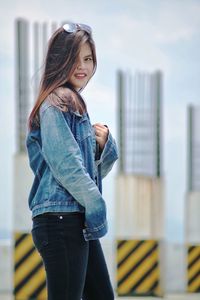 Side view of young woman standing in city