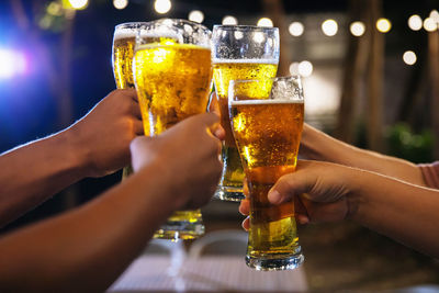 Midsection of man holding beer glass