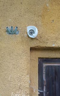 Low angle view of open door on wall of building