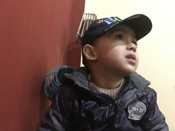 Portrait of boy looking away against wall