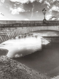 View of bridge over river against cloudy sky