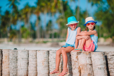 Full length of mother and girl sitting outdoors