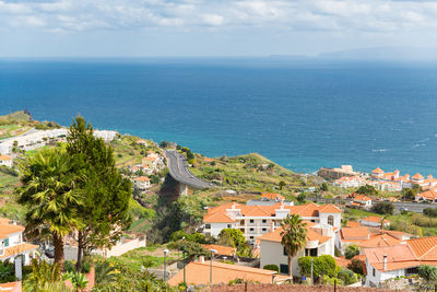 High angle view of townscape by sea against sky