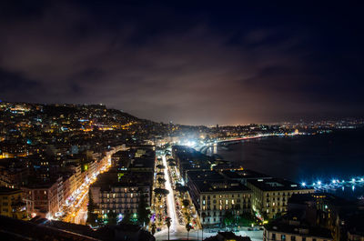 Illuminated cityscape against sky at night