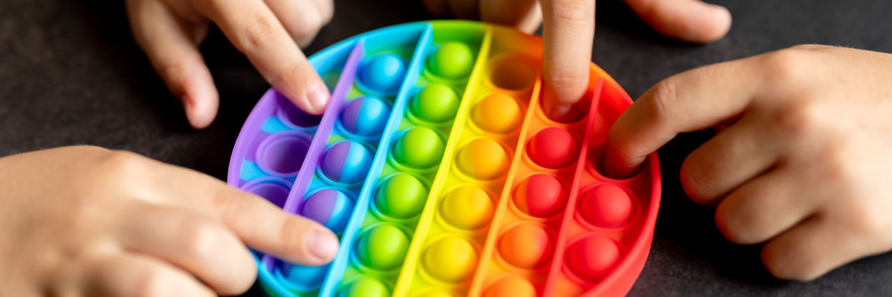 HIGH ANGLE VIEW OF PEOPLE PLAYING WITH MULTI COLORED BABY