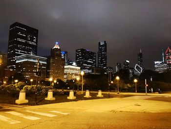 Illuminated buildings in city against sky at night