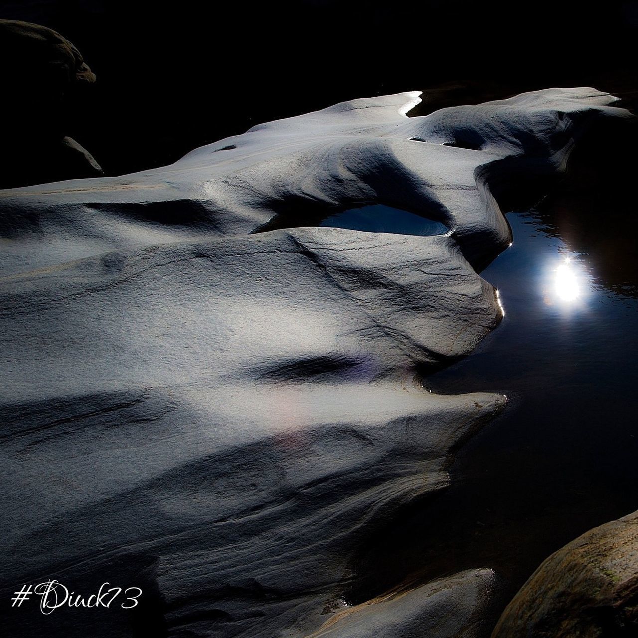 night, close-up, high angle view, nature, no people, text, indoors, rock - object, dark, sunlight, tranquility, part of, vignette, white color, western script, winter, beauty in nature, mountain