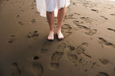 Low section of woman standing at beach