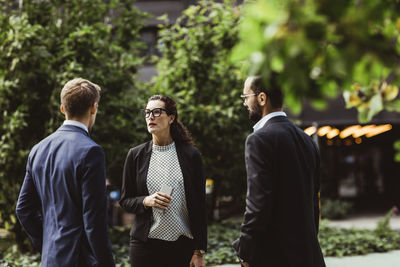 Female and male entrepreneurs discussing business strategy while standing outdoors