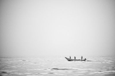 People on sea against clear sky