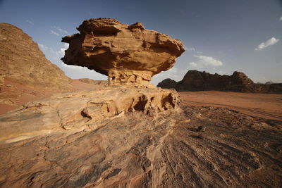 Low angle view of rock formation against sky during sunny day