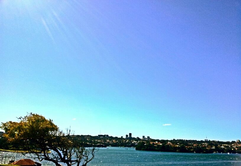 clear sky, blue, copy space, water, built structure, waterfront, architecture, building exterior, tree, scenics, tranquility, tranquil scene, beauty in nature, nature, sea, outdoors, river, idyllic, day, house