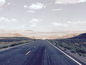 Road passing through landscape against sky