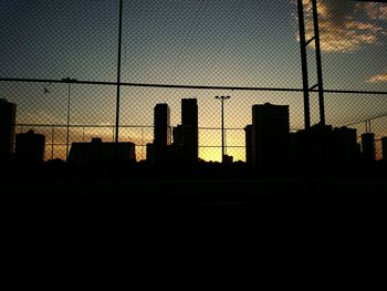 Silhouette of buildings against sky at sunset