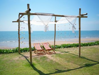 Entertainment tent with chairs at beach against clear blue sky