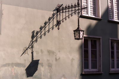 Electric lamp hanging on wall of building