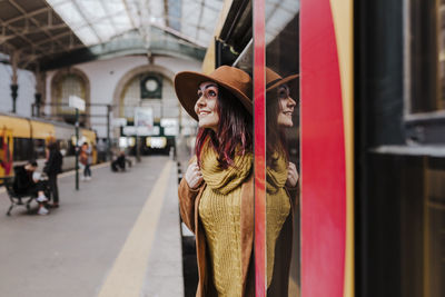 Smiling woman standing at entrance of train