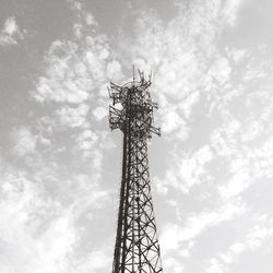 Low angle view of cellular tower against cloudy sky