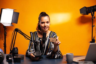 Portrait of young woman using mobile phone while standing in gym