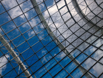 Low angle view of glass building against sky