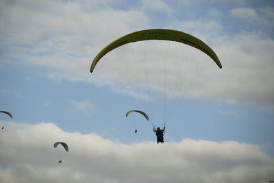 Low angle view of person paragliding against sky