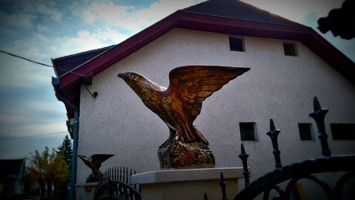 Low angle view of bird statue against building