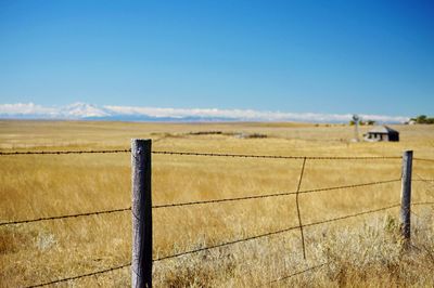 Fence on field against sky