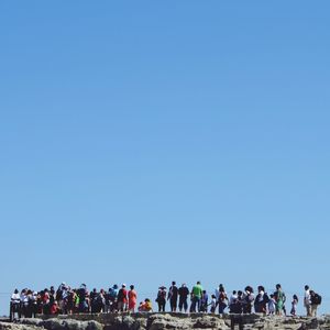 People against clear blue sky