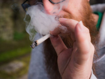 Midsection of man smoking marijuana joint