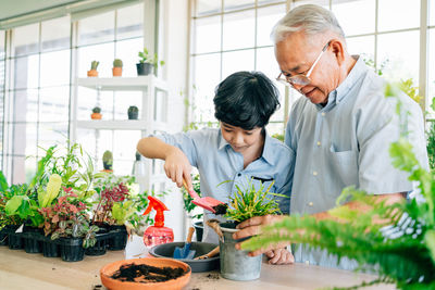 Friends standing by potted plants