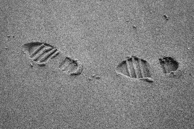 High angle view of shoe prints on sand at beach