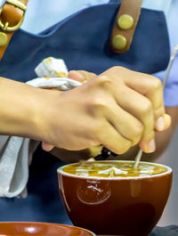 Close-up of hand holding tea cup on table