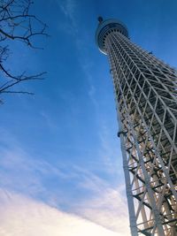 Low angle view of communications tower against cloudy sky