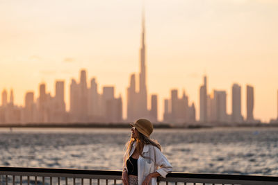 Rear view of woman standing against sea