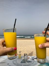 Close-up of hand holding drink on table