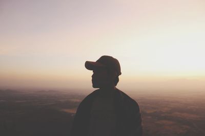 Rear view of silhouette man standing against sky during sunset