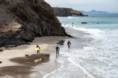 People walking on beach against sky