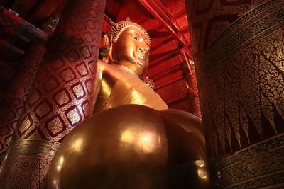 Low angle view of buddha statue against building