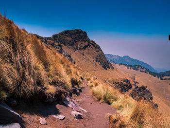 Scenic view of mountains against blue sky