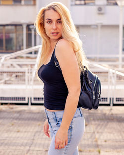 Portrait of young woman standing in city