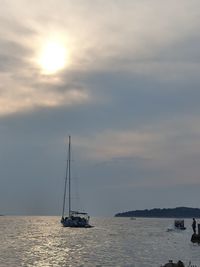 Sailboat sailing on sea against sky during sunset