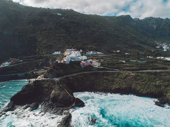 Scenic view of sea by buildings against sky