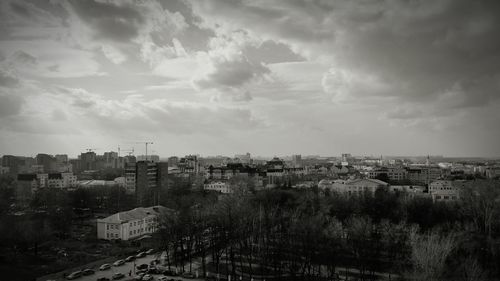 Buildings in town against cloudy sky