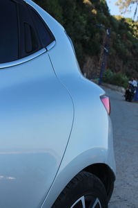 Close-up of car on road against blue sky