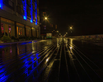 Light trails on street amidst illuminated buildings in city at night